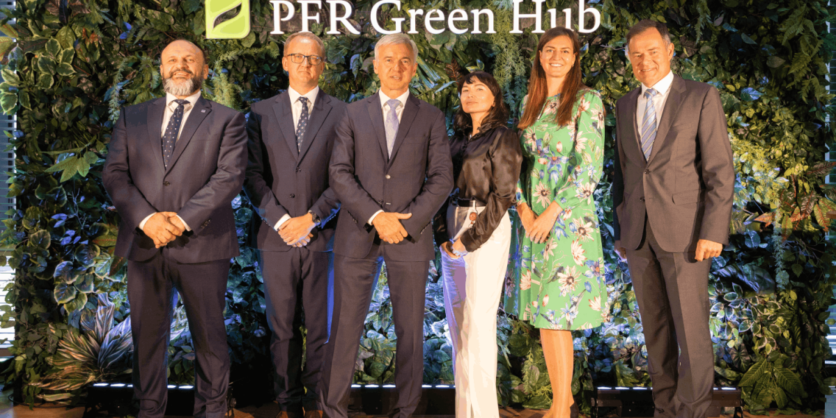 Grupa osób stojących na scenie w szeregu