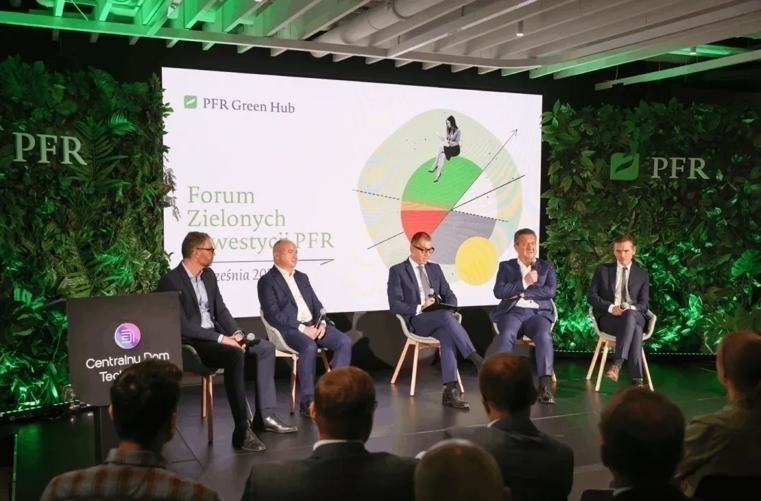 Grupa mężczyzna siedzących na scenie w półokręgu