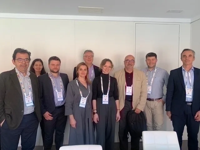 Grupa osób pozująca do zdjęcia przy ścianie